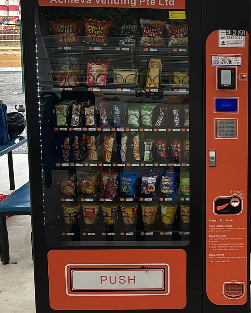 An Achieva snack vending machine on a worksite, stocked with crisps and confectionery