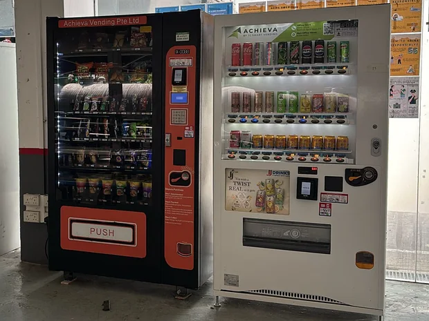 Achieva snack and drinks machines beside lockers in a worker dormitory